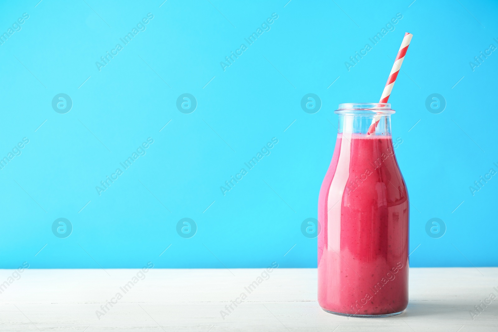 Photo of Bottle with delicious detox smoothie on table