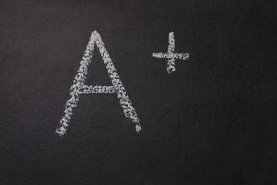 Photo of School grade. Letter A with plus symbol on blackboard, top view. Space for text