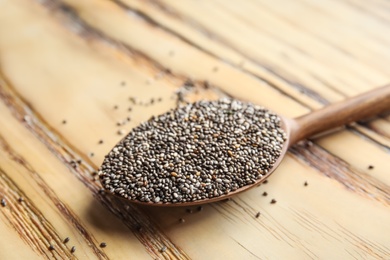 Photo of Spoon with chia seeds on wooden background