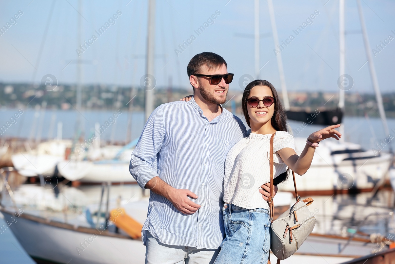 Photo of Young hipster couple in jean clothes on pier