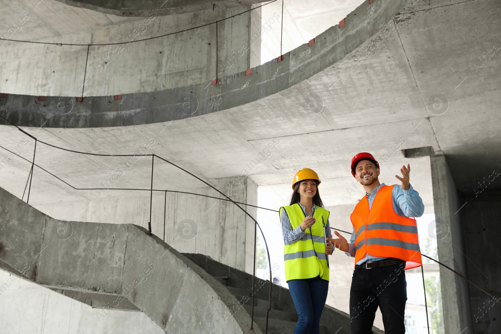 Photo of Professional engineers in safety equipment at construction site. Space for text.