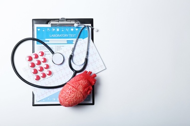 Photo of Composition with stethoscope and pills on white background. Cardiology service