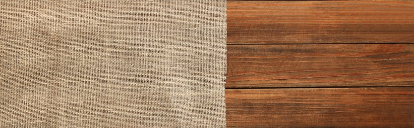 Burlap fabric on wooden table, top view. Space for text