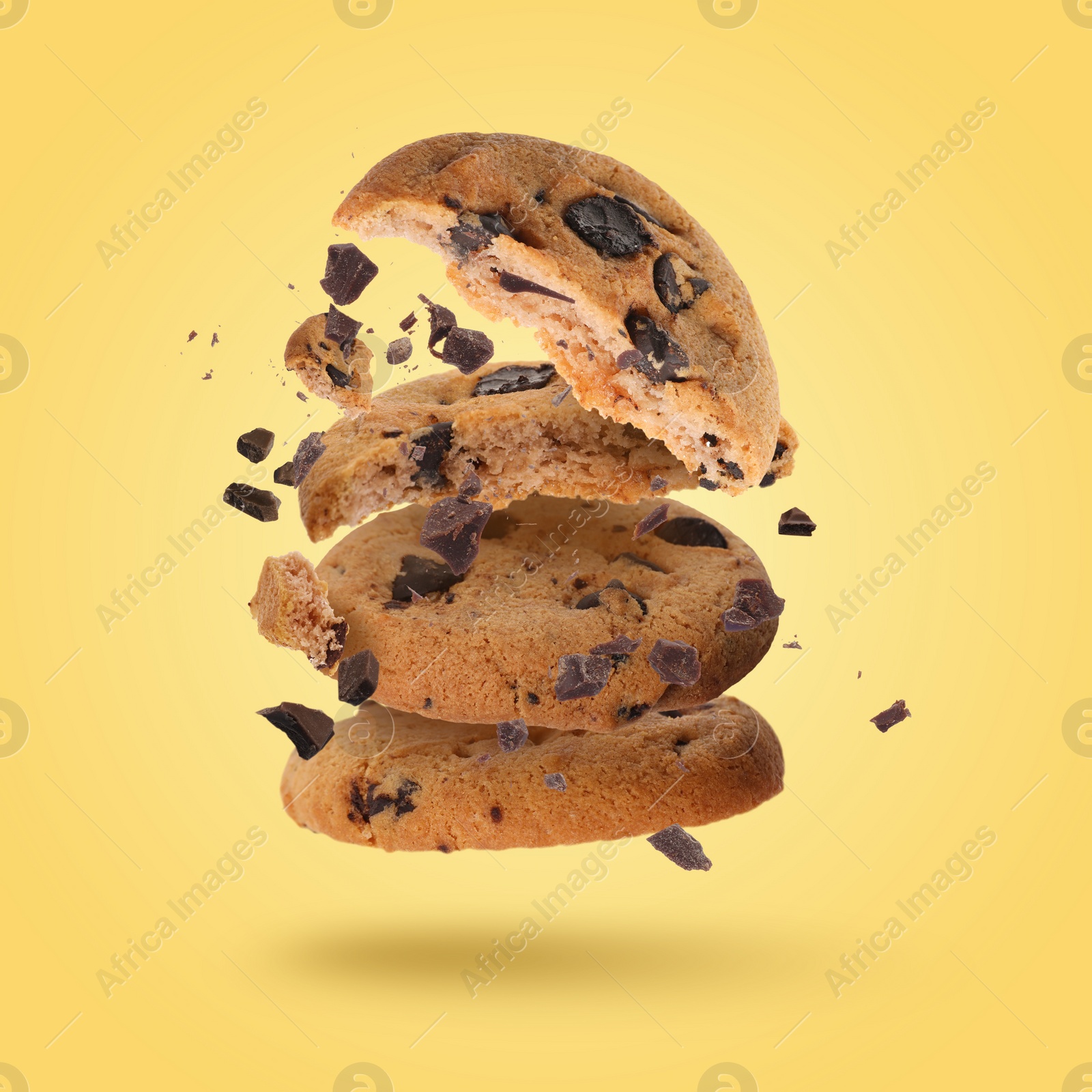 Image of Tasty chocolate chip cookies falling on gold background