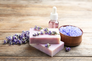 Photo of Composition with handmade soap bars and lavender flowers on brown wooden table