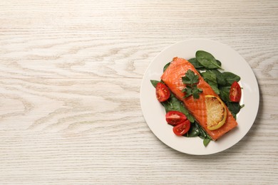 Photo of Tasty grilled salmon with tomatoes, lemon and basil on white wooden table, top view. Space for text