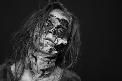 Scary zombie on dark background, black and white effect. Halloween monster