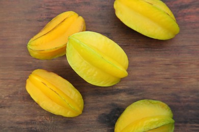 Photo of Delicious ripe carambolas on wooden table, flat lay