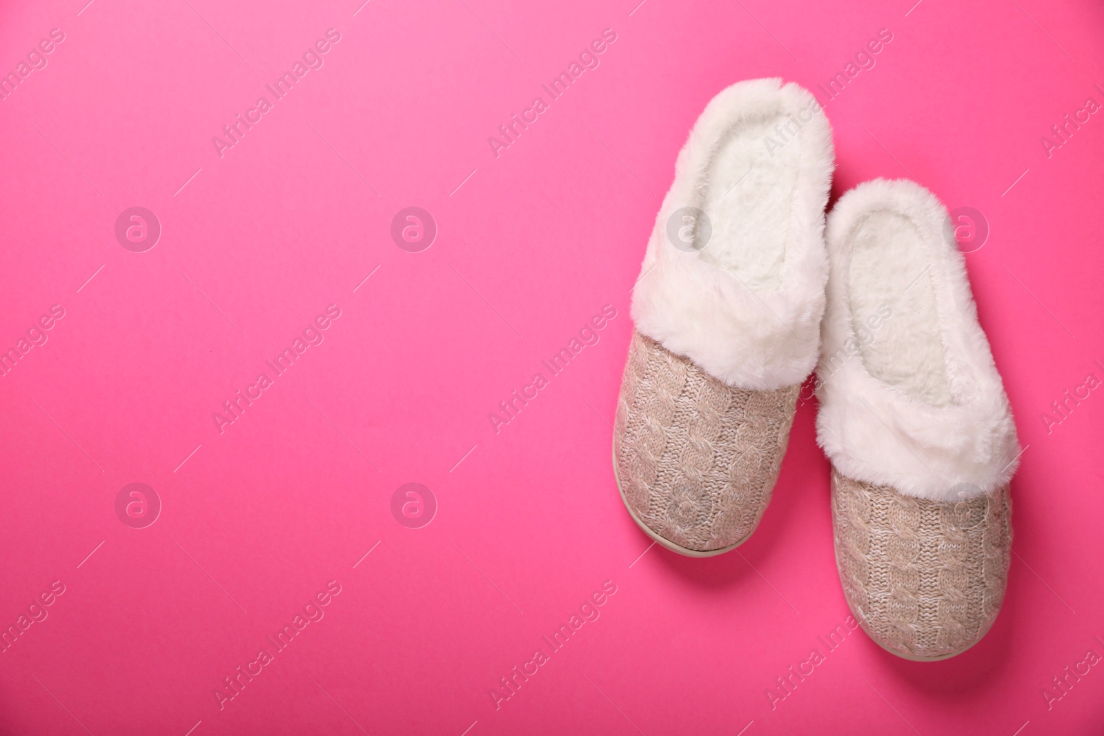 Photo of Pair of beautiful soft slippers on pink background, top view. Space for text