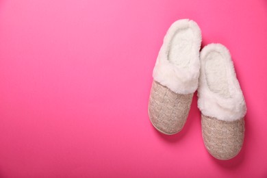 Photo of Pair of beautiful soft slippers on pink background, top view. Space for text