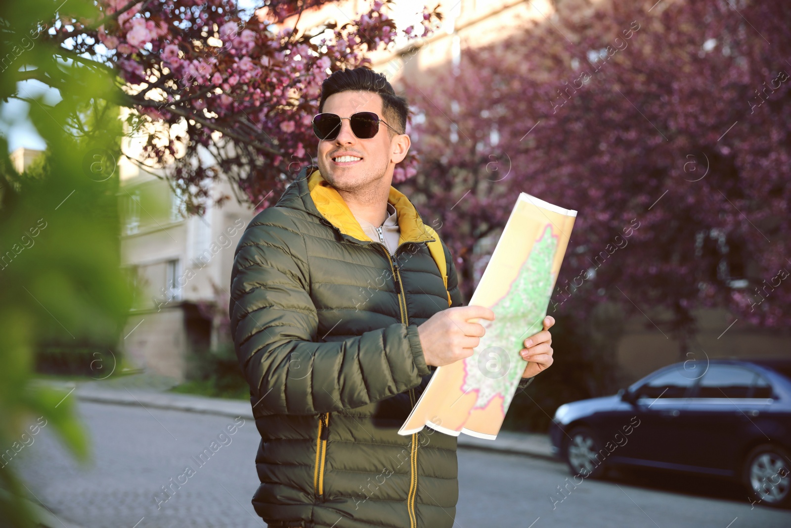 Photo of Happy male tourist with map on city street