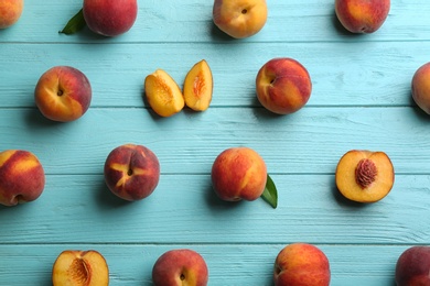 Photo of Fresh sweet peaches on turquoise wooden table, flat lay