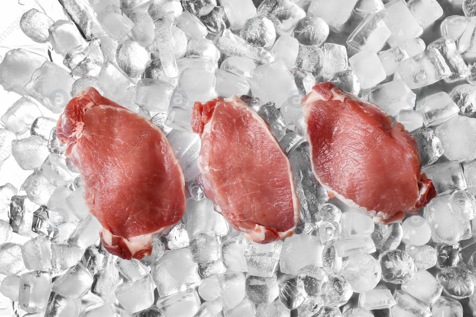 Photo of Fresh raw meat on ice cubes, flat lay