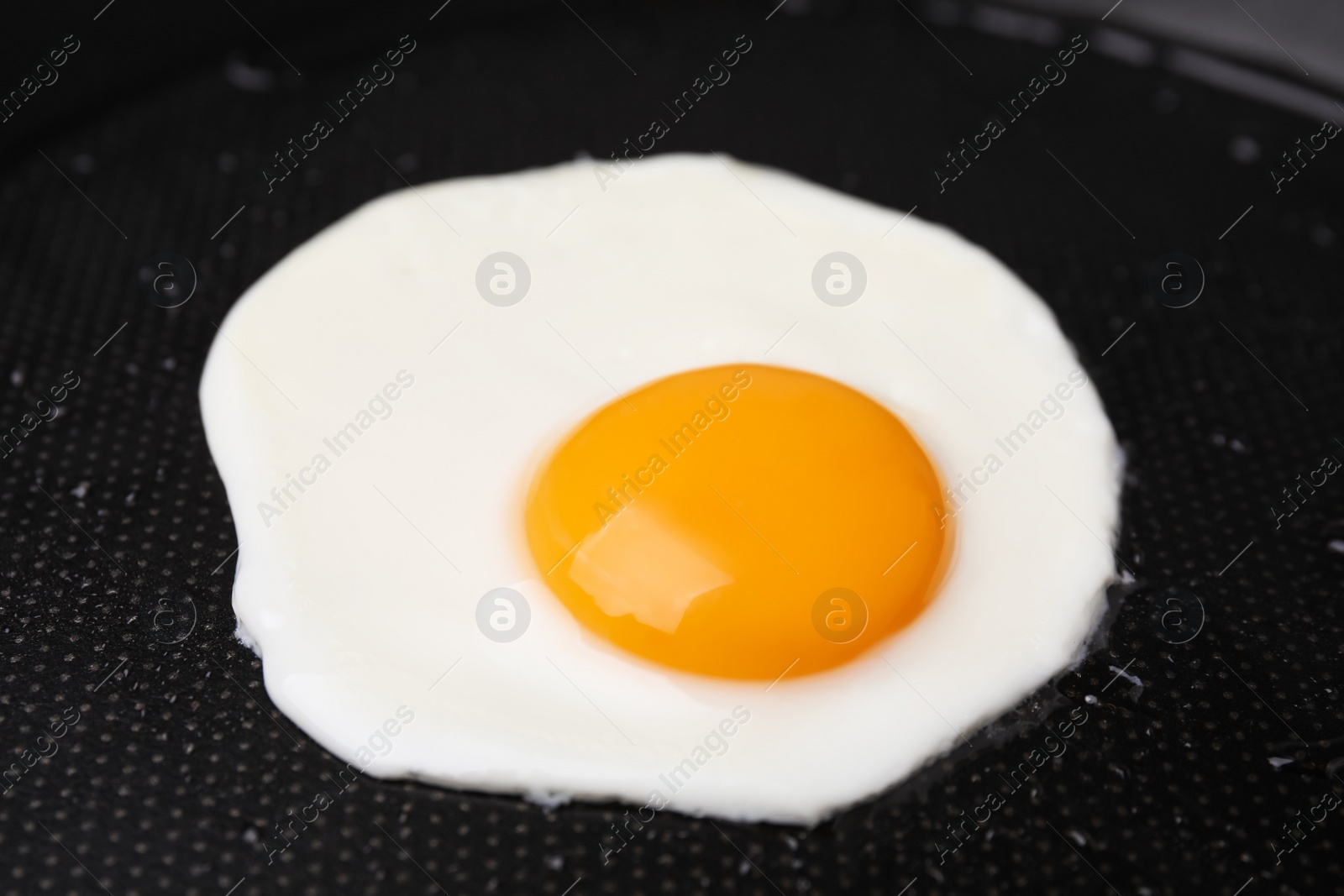 Photo of Tasty fried egg in pan, closeup view