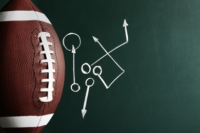 Photo of Chalkboard with football game scheme and rugby ball, top view. Space for text
