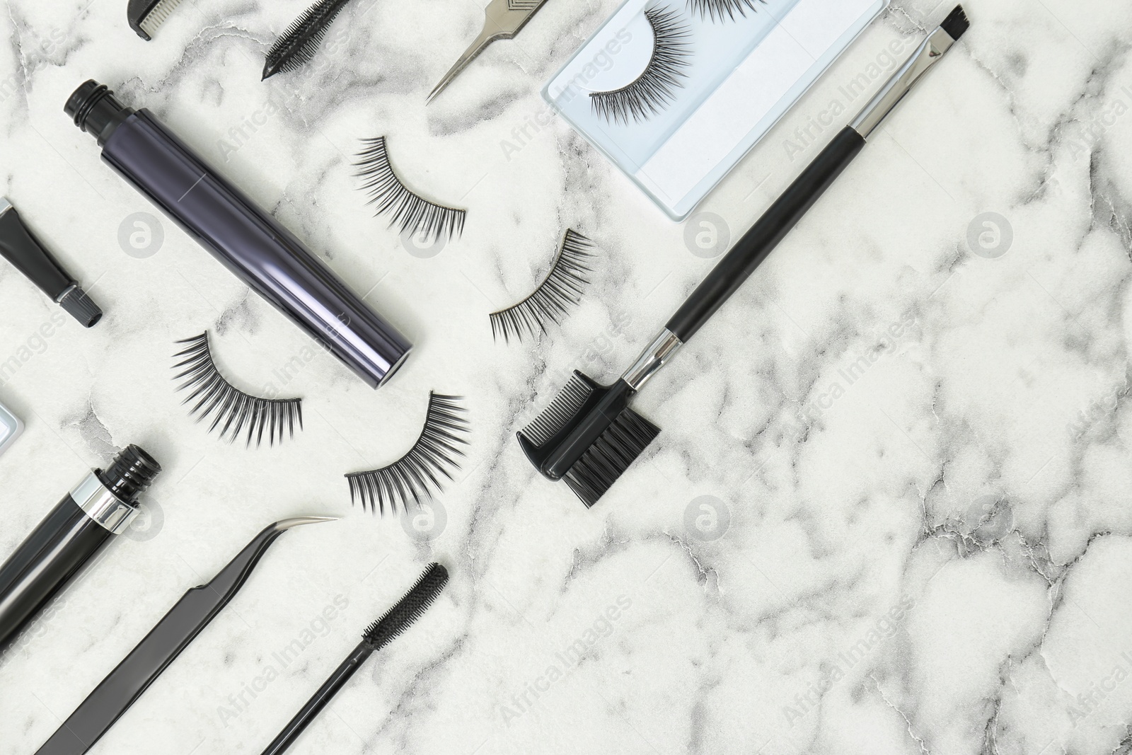 Photo of Flat lay composition with false eyelashes and cosmetic tools on light background