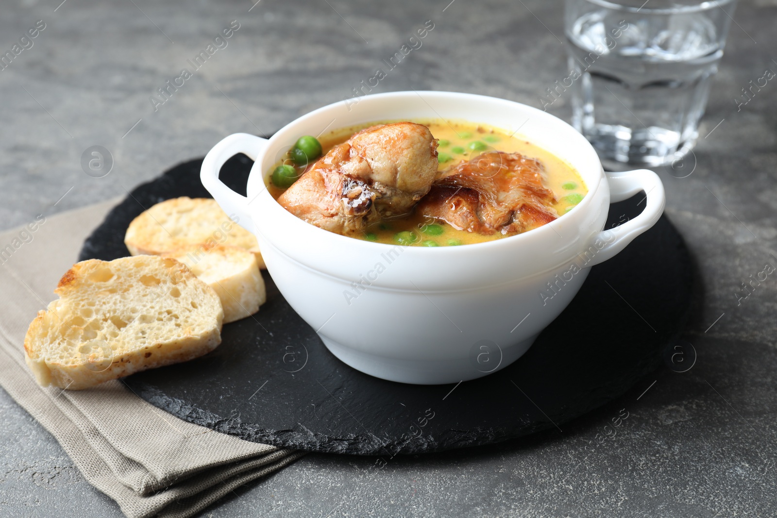 Photo of Tasty cooked rabbit meat with sauce served on grey table, closeup