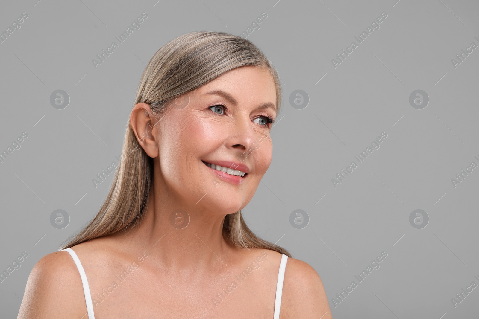 Photo of Beautiful mature woman with healthy skin on gray background, space for text