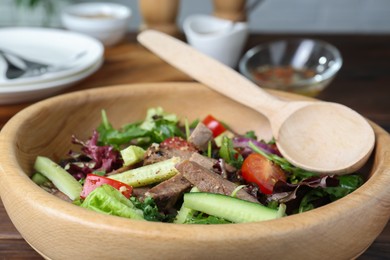 Delicious salad with beef tongue, vegetables and spoon served on table, closeup