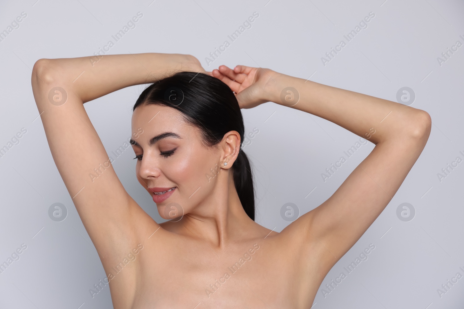 Photo of Young woman showing smooth skin after epilation on white background