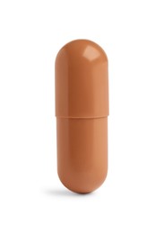 Photo of One brown pill on white background. Medicinal treatment