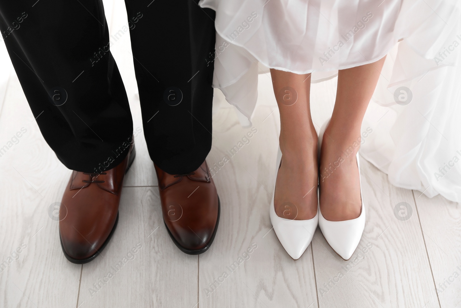 Photo of Bride and groom wearing elegant classic wedding shoes indoors, closeup