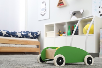 Photo of Toy walker on floor in child's room, space for text. Interior design