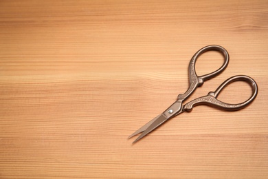 Vintage scissors on wooden background. Tailoring tool