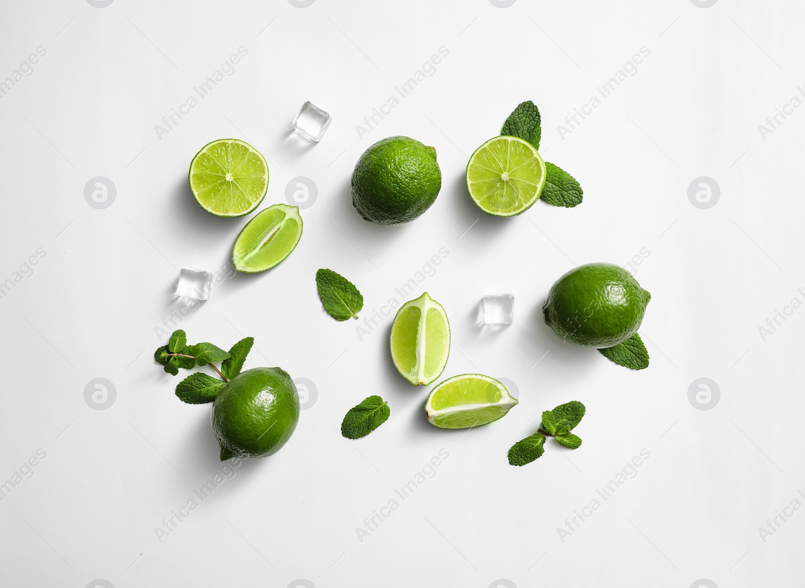 Photo of Flat lay composition with fresh juicy limes, mint and ice cubes on white background