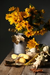Photo of Beautiful autumn bouquet, small pumpkins and corn cobs on wooden table against dark grey background