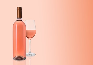 Image of Bottle and glass of delicious rose wine on pink background. Space for text