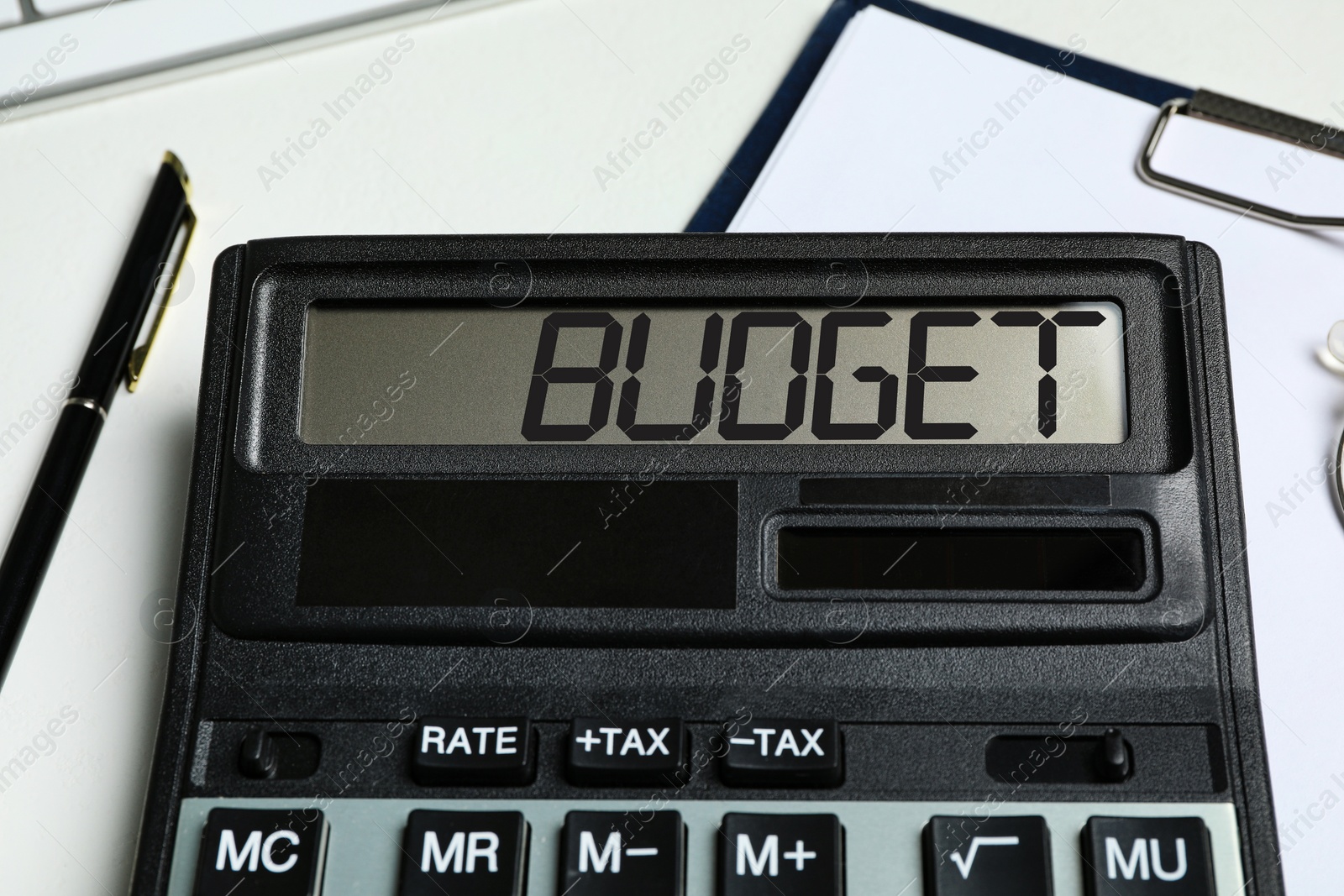 Image of Calculator with word Budget, documents and pen on table, closeup