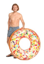 Attractive young man in swimwear with doughnut inflatable ring on white background