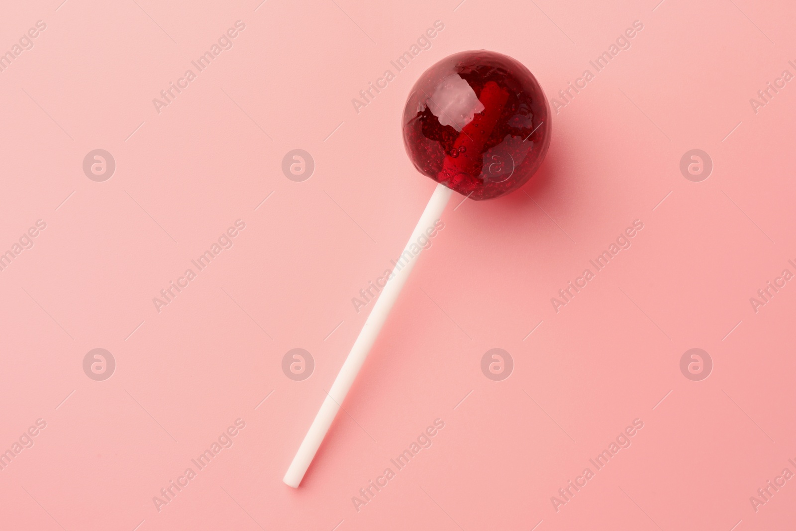 Photo of Tasty lollipop on pink background, top view