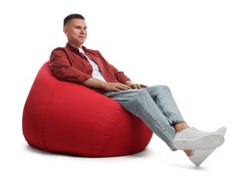 Photo of Handsome man sitting on red bean bag chair against white background