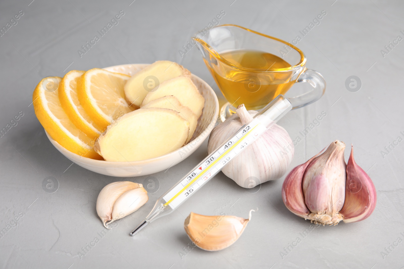 Photo of Composition with garlic and other cold remedies on grey table