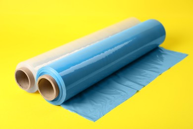 Photo of Rolls of different stretch wrap on yellow background