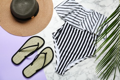 Photo of Flat lay composition with striped swimsuit and beach accessories on color background