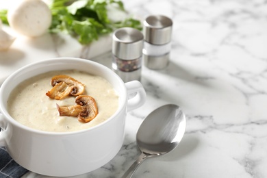 Delicious cream soup with mushrooms on white marble table. Space for text