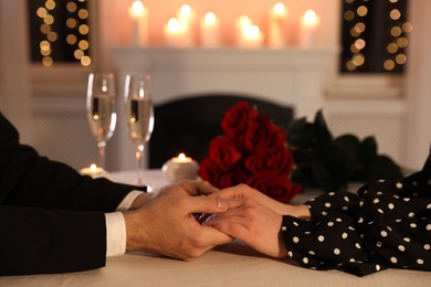 Photo of Couple holding hands together at table during romantic dinner in restaurant, closeup