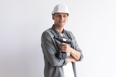 Photo of Young working man with electric screwdriver on white background