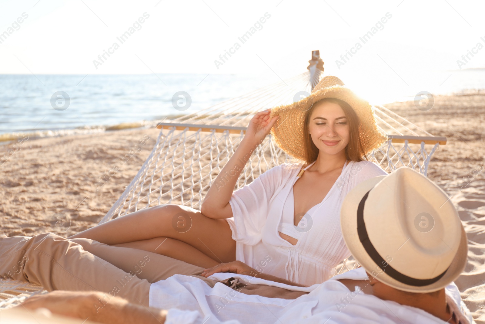 Photo of Happy couple relaxing in hammock on beach