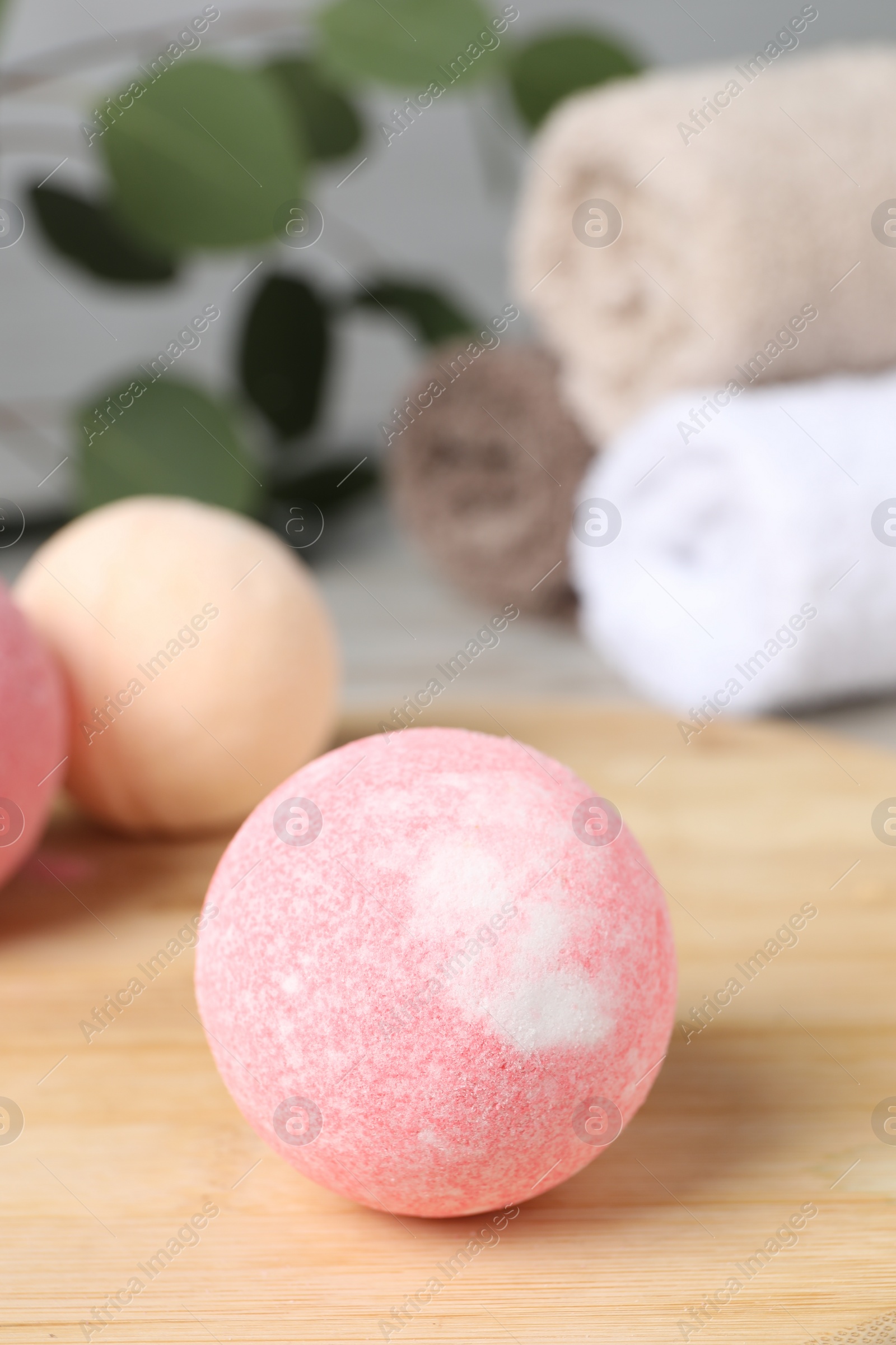 Photo of Beautiful aromatic bath bomb on wooden board, closeup. Space for text