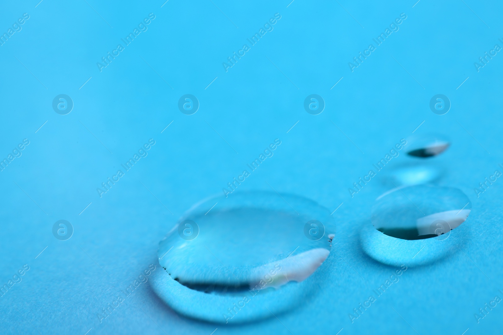 Photo of Pure water drops on color background, closeup. Space for text