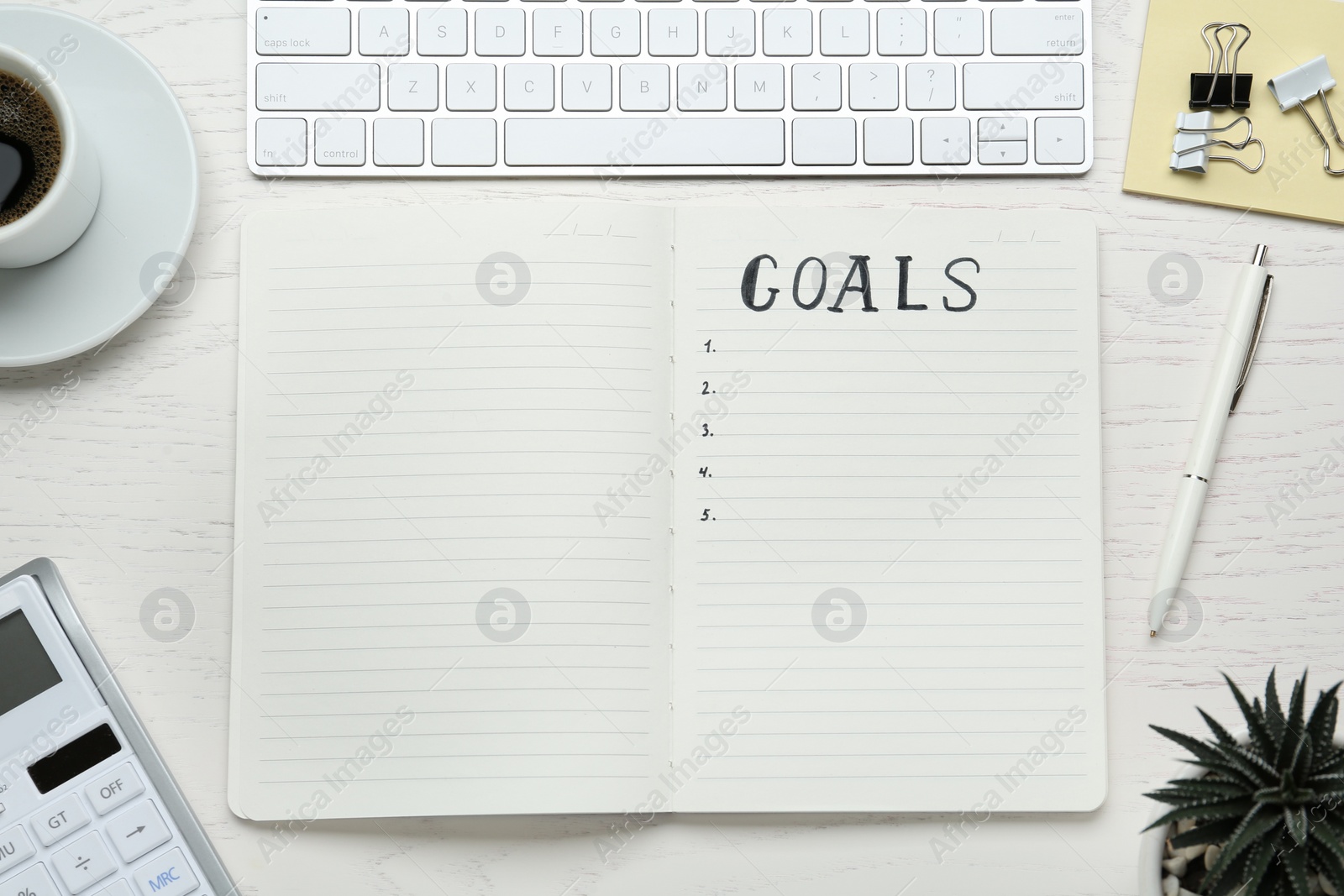 Photo of Flat lay composition with notebook and computer keyboard on white wooden table. Goals for New Year 2021