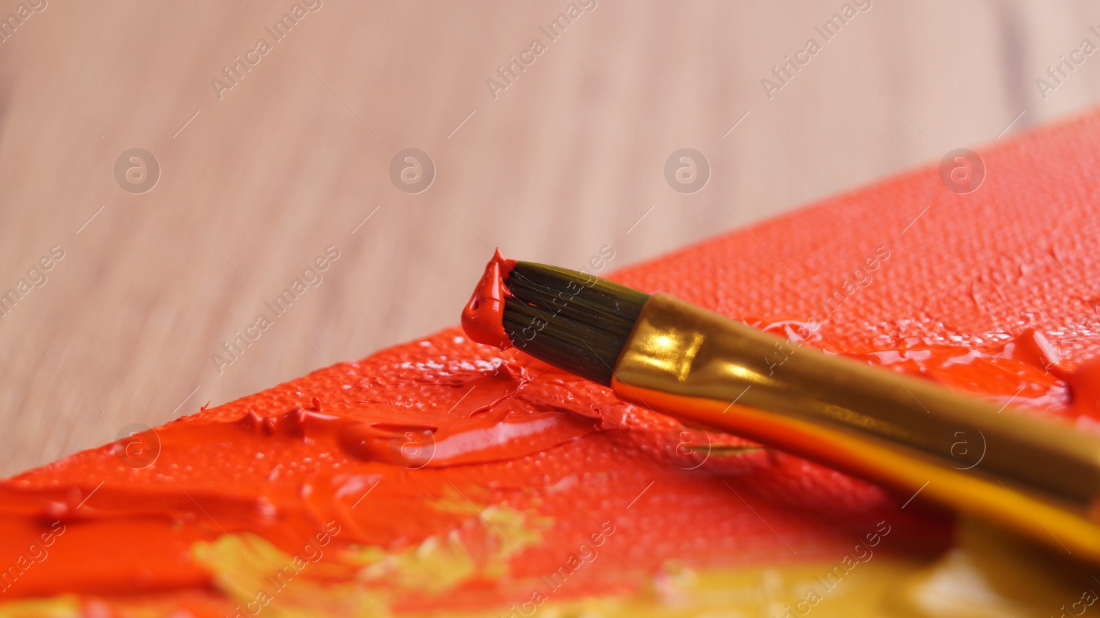 Photo of Brush on artist's palette with colorful mixed paints, closeup