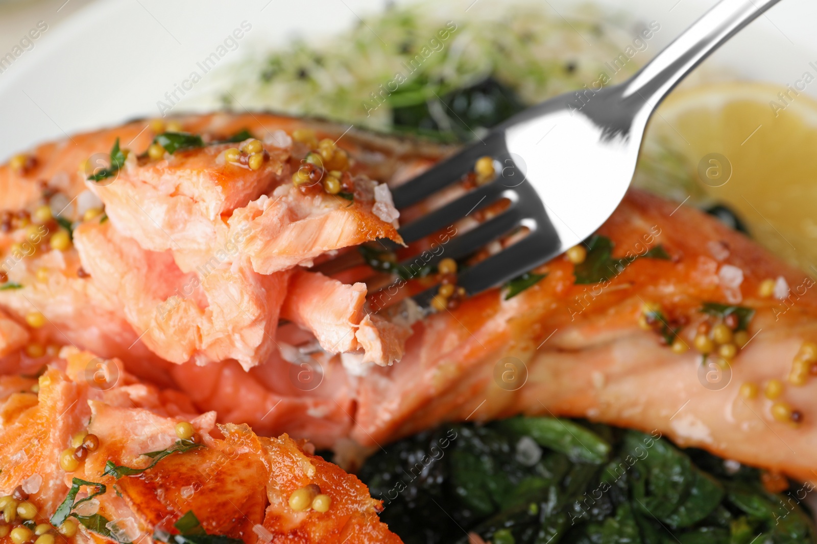 Photo of Tasty salmon with spinach on plate, closeup