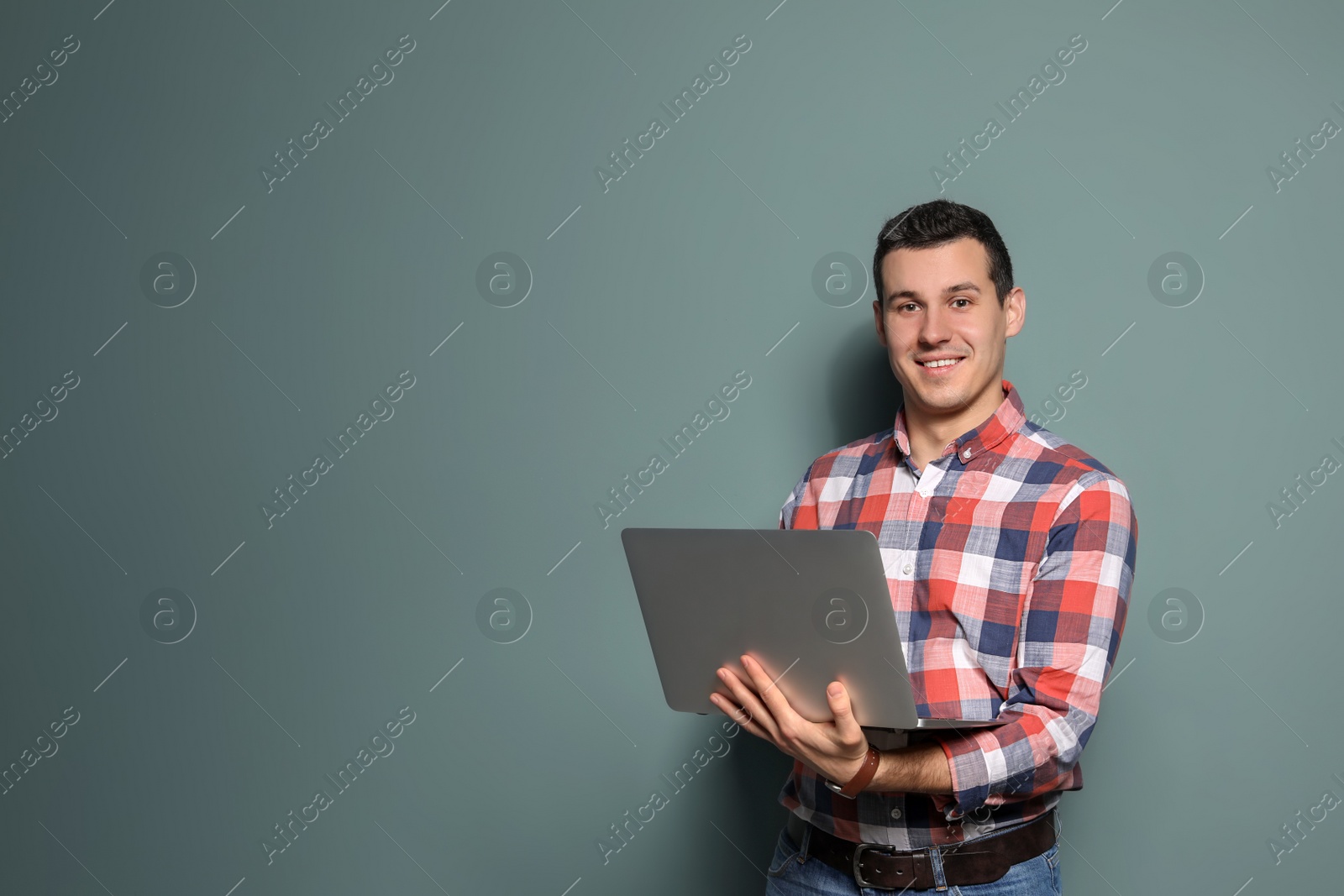 Photo of Portrait of confident man with laptop on color background