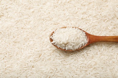 Photo of Raw basmati rice and spoon, top view