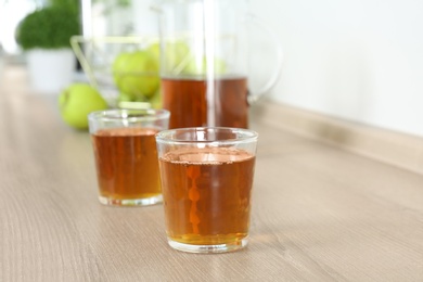 Photo of Glasses of fresh apple juice on wooden table